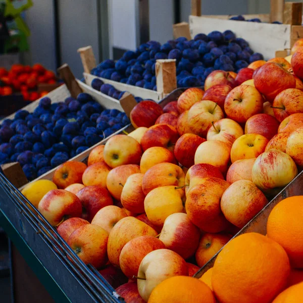Apples, oranges and plums for sale at a market