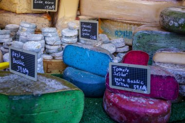 Fransız pazarında mavi, pembe, yeşil, farklı renkte Fransız peyniri.