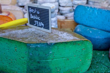 Fransız pazarında mavi, pembe, yeşil, farklı renkte Fransız peyniri.