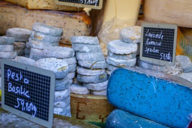 Fransız pazarında mavi, pembe, yeşil, farklı renkte Fransız peyniri.