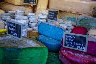 Fransız pazarında mavi, pembe, yeşil, farklı renkte Fransız peyniri.