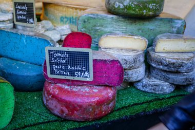 Fransız pazarında mavi, pembe, yeşil, farklı renkte Fransız peyniri.