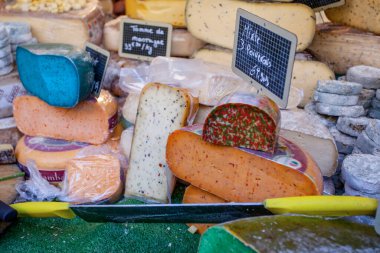 Fransız pazarında mavi, pembe, yeşil, farklı renkte Fransız peyniri.