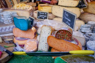 Fransız pazarında mavi, pembe, yeşil, farklı renkte Fransız peyniri.