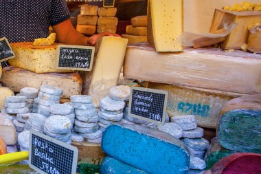 Fransız pazarında mavi, pembe, yeşil, farklı renkte Fransız peyniri.