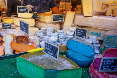 Fransız pazarında mavi, pembe, yeşil, farklı renkte Fransız peyniri.