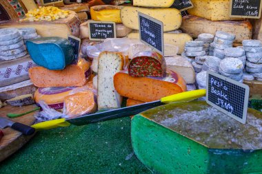 Fransız pazarında mavi, pembe, yeşil, farklı renkte Fransız peyniri.