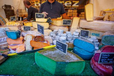 Fransız pazarında mavi, pembe, yeşil, farklı renkte Fransız peyniri.