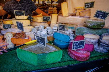 Fransız pazarında mavi, pembe, yeşil, farklı renkte Fransız peyniri.