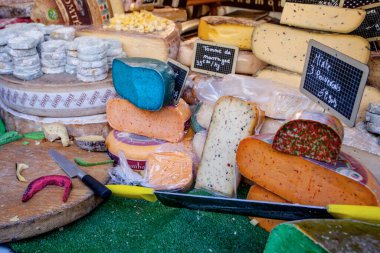 Fransız pazarında mavi, pembe, yeşil, farklı renkte Fransız peyniri.