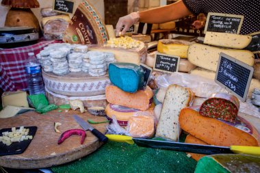 Fransız pazarında mavi, pembe, yeşil, farklı renkte Fransız peyniri.