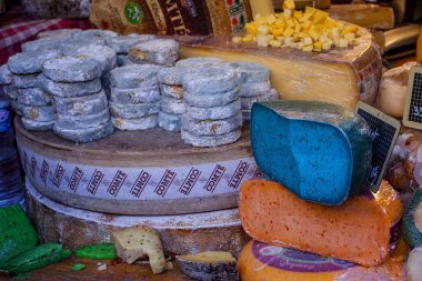 Fransız pazarında mavi, pembe, yeşil, farklı renkte Fransız peyniri.