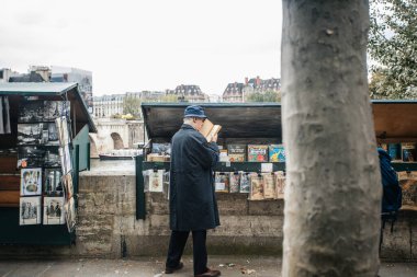 PARIS, FRANCE - 7 Ekim 2016: Notre-Dame katedralinin önündeki Seine nehrinin kenarındaki geleneksel Bouquiniste standı. Buketler kullanılmış ve antika kitapların yanı sıra hediyelik eşya da satıyorlar..