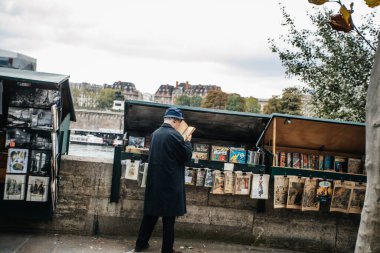 PARIS, FRANCE - 7 Ekim 2016: Notre-Dame katedralinin önündeki Seine nehrinin kenarındaki geleneksel Bouquiniste standı. Buketler kullanılmış ve antika kitapların yanı sıra hediyelik eşya da satıyorlar..
