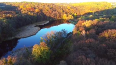 Golosievo parkında insansız hava aracıyla çekilen güzel göl ve sonbahar ormanlarının manzarası.