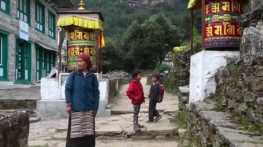 Gorkha, Nepal - 6 Ekim 2019: Dağlık köyün sokaklarında çocuklu Nepalli kadın Everest Ana Kampı 'na gidiyor.