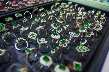 Mücevher pazarında yeşil taşlı renkli yüzükler.