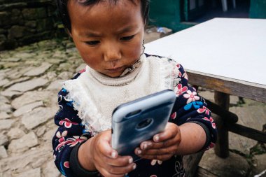 HIMALAYAS, Everest REGION, NEPAL - 20 EKİM 2018: Evinin yakınındaki Himalaya köyündeki sokakta Nepal kızı portresi