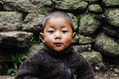 HIMALAYAS, Everest REGION, NEPAL - 20 EKİM 2018: Evlerinin yakınındaki Himalaya köyündeki sokakta Nepal 'li küçük bir çocuğun portresi