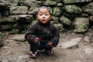 HIMALAYAS, Everest REGION, NEPAL - 20 EKİM 2018: Evlerinin yakınındaki Himalaya köyündeki sokakta Nepal 'li küçük bir çocuğun portresi