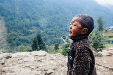 HIMALAYAS, Everest REGION, NEPAL - 20 EKİM 2018: Evlerinin yanında ağlayan Nepal 'li küçük çocuk portresi