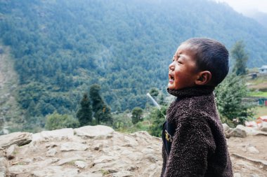 HIMALAYAS, Everest REGION, NEPAL - 20 EKİM 2018: Evlerinin yanında ağlayan Nepal 'li küçük çocuk portresi