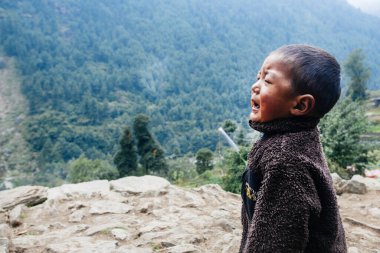 HIMALAYAS, Everest REGION, NEPAL - 20 EKİM 2018: Evlerinin yanında ağlayan Nepal 'li küçük çocuk portresi
