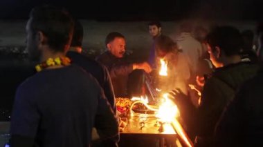 Rishikesh, Uttarakhand - 1 Aralık 2019: Uttarakhand, Hindistan 'ın kutsal kenti Rishikesh' te Ganga arthi adlı akşam töreninde Ganga / Ganj nehrine ibadet etmek için kırmızı cüppeli rahipler.