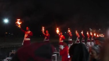 Rishikesh, Uttarakhand - 1 Aralık 2019: Uttarakhand, Hindistan 'ın kutsal kenti Rishikesh' te Ganga arthi adlı akşam töreninde Ganga / Ganj nehrine ibadet etmek için kırmızı cüppeli rahipler.