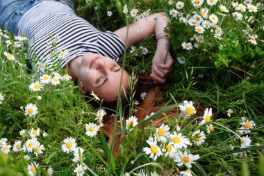 Kahverengi saçlı güzel bir kadın, gülümsüyor, papatya tarlasında.