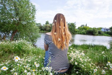 Kahverengi saçlı güzel bir kadın, gülümsüyor, papatya tarlasında.