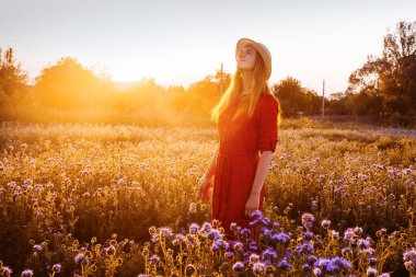 Violet Fas 'taki güzel genç kadın. Gün batımında çiçek tarlası.