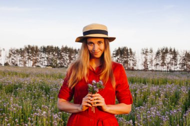 Violet Fas 'taki güzel genç kadın. Gün batımında çiçek tarlası.