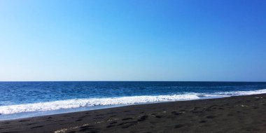 Yunanistan 'ın Perissa plajında Ege Denizi' nin güzel mavi dalgaları çekildi