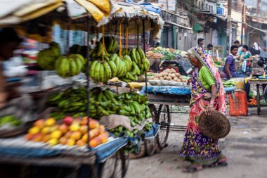 Varanasi, Hindistan - 28 Ekim 2013: Hindistan 'ın Rajasthan kentindeki Jodhpur kentindeki bir sokak pazarında sebze satan son sınıf öğrencisi bir kadın