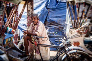 VARANASI, INDIA - 28 Ekim sabahı Varanasi, Hindistan 'da bir sokakta. Hint şehirleri hala insan gücüyle çalışan çekçekçekleri sıradan bir ulaşım aracı olarak kullanıyor.
