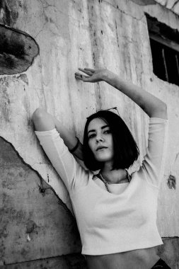 Şehir ortamında beton duvara yaslanan yalnız bir kadın..