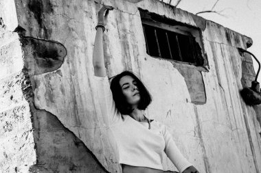 Şehir ortamında beton duvara yaslanan yalnız bir kadın..