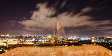 Gece Kudüs 'ün arka planında oturan genç kadın El Aksa Camii ve Zeytin Dağı' yla birlikte.