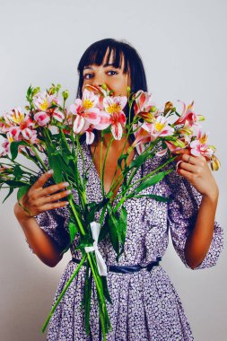 Gülen kadın ellerinde açık gül alstromerya buketi