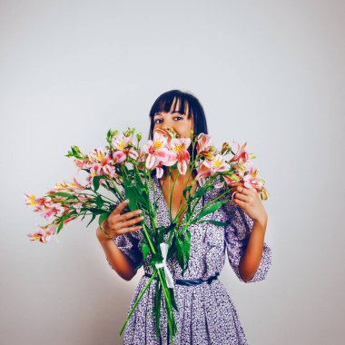 Gülen kadın ellerinde açık gül alstromerya buketi