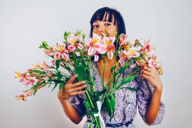 Gülen kadın ellerinde açık gül alstromerya buketi