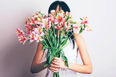 Gülen kadın ellerinde açık gül alstromerya buketi