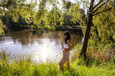 Güneşin doğuşunda gölün yanında güzel genç bir kadın