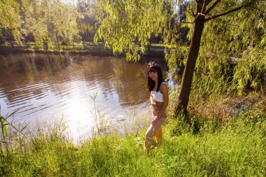 Güneşin doğuşunda gölün yanında güzel genç bir kadın