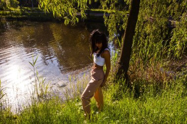 Güneşin doğuşunda gölün yanında güzel genç bir kadın