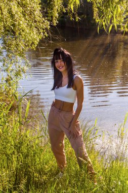 Güneşin doğuşunda gölün yanında güzel genç bir kadın