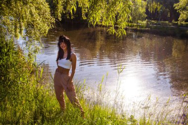 Güneşin doğuşunda gölün yanında güzel genç bir kadın