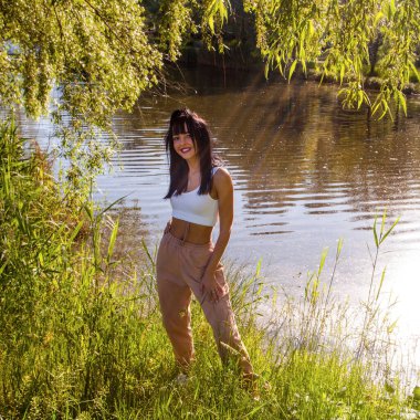 Güneşin doğuşunda gölün yanında güzel genç bir kadın