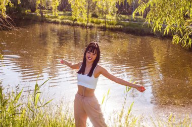 Güneşin doğuşunda gölün yanında güzel genç bir kadın